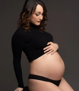 Donna incinta con abito semplice e sfondo pulito a Bra.